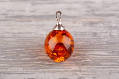 Parlak konyak renginde büyük bir kehribar damlası şeklinde kolye