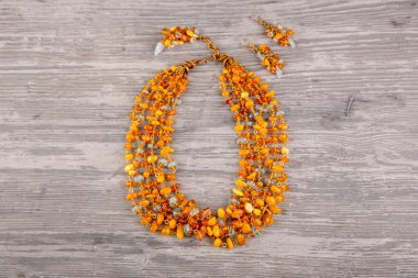 Eski kehribar rengi parlak turuncu renkte doğal akuamarinlerden yapılmış kolyeler ve küpeler. 6 sıralı kolye el yapımı bronz bir zincir üzerine monte edilmiş. Collier, kehribar ve akuamarin yapraklarıyla bronz bir zincir tamamlıyor.