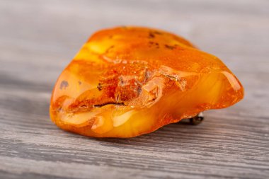 Kehribarın doğal ham bir parçasından gümüş bir kilidin üzerindeki broş.