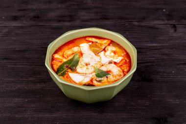 Tom tatlı patates çorbası, deniz ürünleri ve hindistan cevizi sütü ile servis edilir.