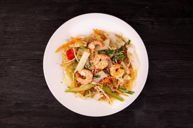 Susamlı deniz ürünleri, cam erişte ve havuçla servis edilir.