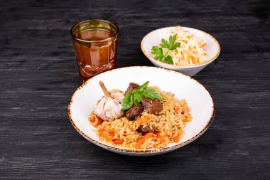 Bir yığın kuzu, taze lahana salatası ve komposto ile servis edilir.