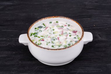 Taze sebzeli okroshka, kefir ve yeşillikle servis edilir.