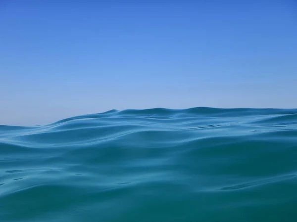 Silky wave that goes toward beach with crystal blue water and great sky in the back