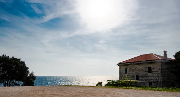 The sky look bigger from this perspective, with sea, house and bright blue day