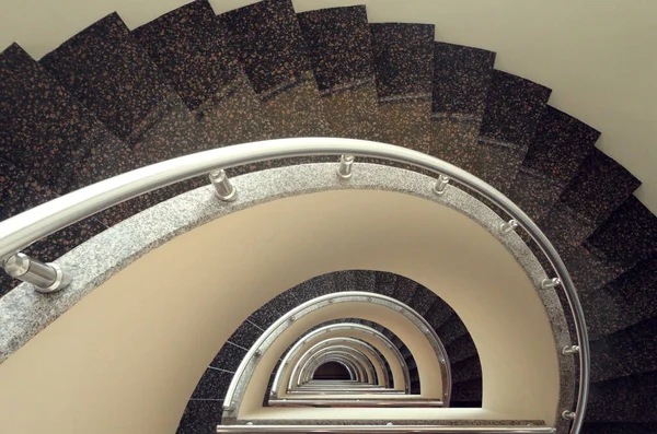 Half circle, half spiral stairs made from reflected brown stone
