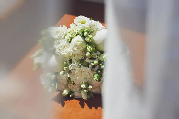 Pencere kenarında narin bir buket beyaz çiçek. Perdelerin arkasını gör. Gelinin sabahı