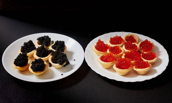 Tartlets Full Red Black Caviar Black Background White Plates — Zdjęcie stockowe