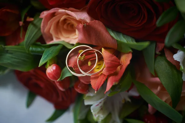 Arany Gyűrűk Egy Gyönyörű Menyasszonyi Csokor Rózsa Háttérben Részletek Esküvői — Stock Fotó