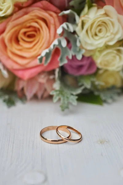 Guld Ringar Och Vacker Brudbukett Rosor Bakgrunden Detaljer Bröllopstraditioner Närbild — Stockfoto