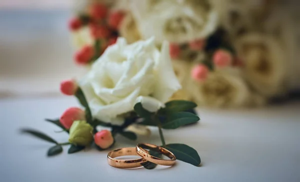 Guld Ringar Och Vacker Brudbukett Rosor Bakgrunden Detaljer Bröllopstraditioner Närbild — Stockfoto