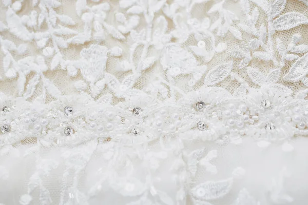 Boncuklarla, yapay elmaslarla ve pullarla işlenmiş bir gelinlik dokusu. Yakın çekim, makro
