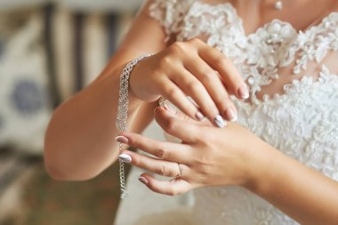 Gelin, kristallerden ve yapay elmaslardan yapılmış lüks bir bilezik takıyor. Düğüne hazırlanıyorum. Yakın çekim, makro