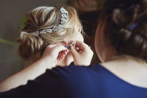 Nedime küpenin takılmasına yardım ediyor. Düğüne hazırlanıyorum. Yakın çekim, makro