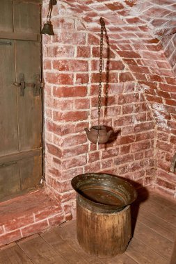 Bakır bir leğenin üzerindeki zincirde asılı antika bir lavabo..