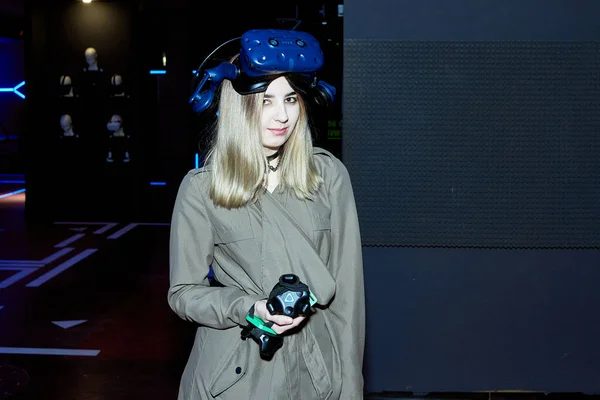 Sanal gerçeklik gözlüklü ve elinde oyun kumandası olan güzel bir genç kız..