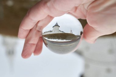 A glass ball with a reflection of the sights. Optical illusion, effect. Close-up, macro