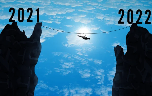 Man balancing between two cliff. From 2021 to 2022. Happy New year for climbers and adventures concepts