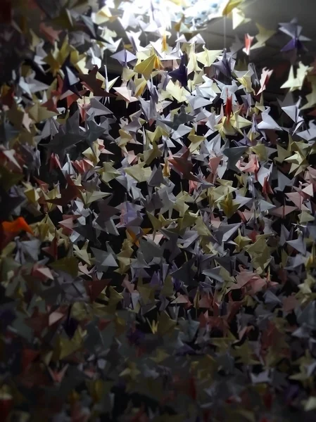 Handgemaakte gekleurde origami kraanvogels op het plafond van tekenreeksen textuur achtergrond — Stockfoto