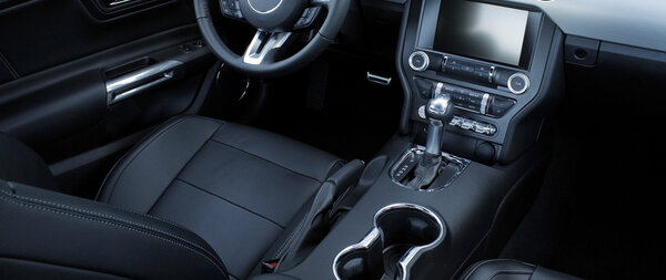 Black leather and chrome parts in car interior 