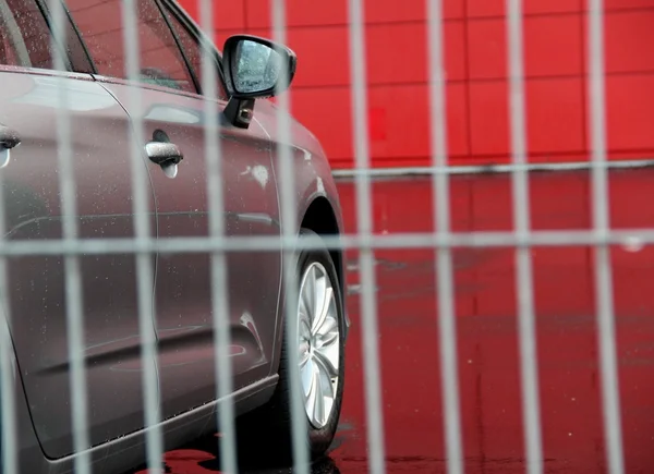 New car behind security greed near car shop — Stock Photo, Image