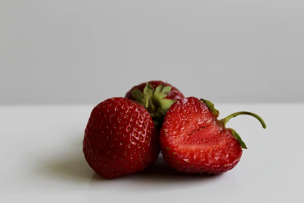 在白色背景查出的整体和切开的草莓 — 图库照片