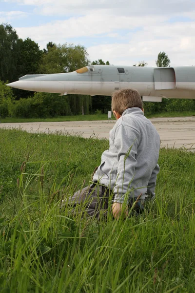 Junge auf der Landebahn nahe Riesenflugzeug auf Militärflugzeugbasis — Stockfoto
