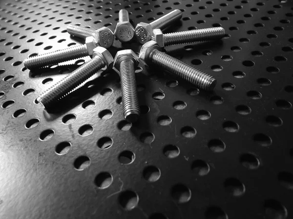 Hardware-Symbol. Sechskantschrauben in Blütenform auf Aluminiumoberfläche — Stockfoto
