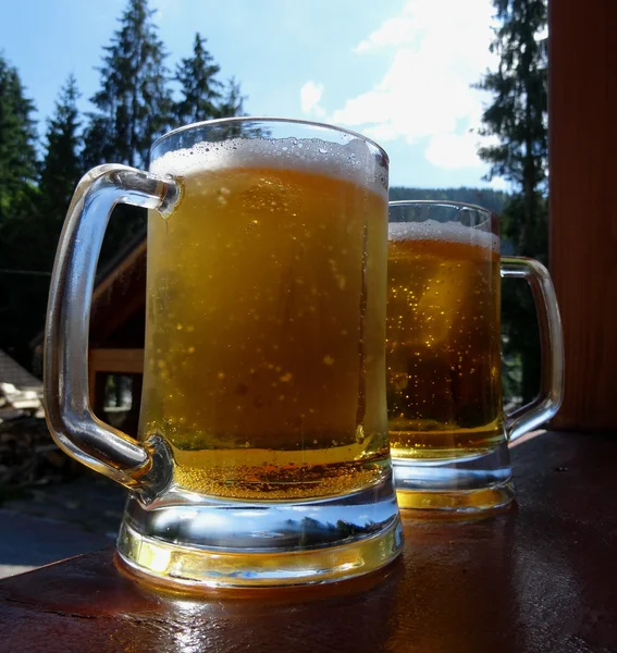 Prywatny browar. Szklanki piwa na biurko z drewna na dziedzińcu browaru — Zdjęcie stockowe