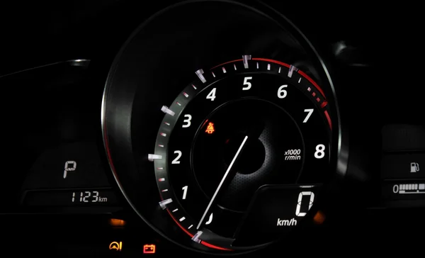 Макро знімок тахометра автомобіля з білим циферблатом і блискучою голкою на приладовій панелі автомобіля — стокове фото