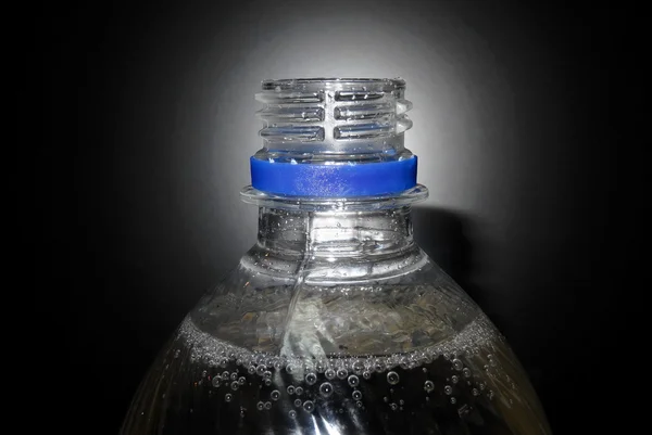Parte superior da garrafa de água mineral espumante no fundo preto isolado — Fotografia de Stock