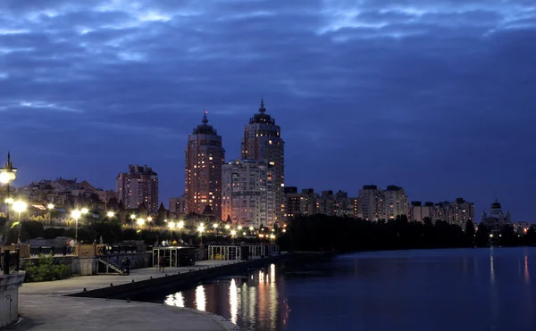 Міська набережна з вуличними ліхтарями відображення у воді вночі — стокове фото