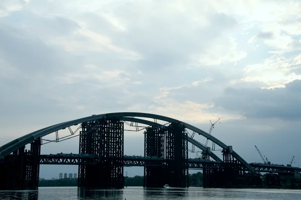 Construction d'un pont en arc d'acier au-dessus du fleuve — Photo