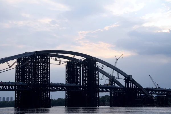 Construction d'un pont en arc d'acier au-dessus du fleuve — Photo