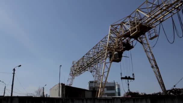 Gantry overhead crane loads scrap metal at junk yard — Stock Video