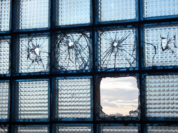 City war. Bullet marks on broken window glass with city scape in the holes — Stock Photo, Image