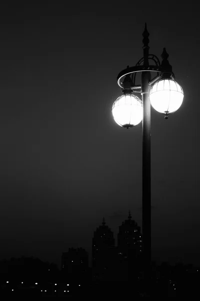 A város épületek sziluett éjszakai utcai lámpák — Stock Fotó