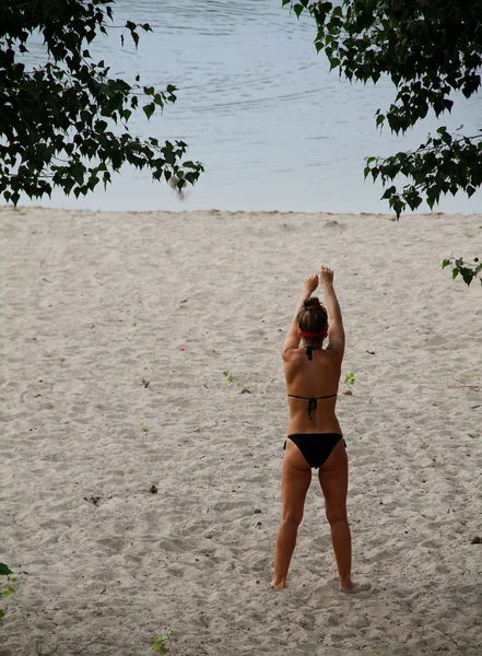 Sexy Frau im Bikini engagiert Fitness auf dem Sand am Strand — Stockfoto