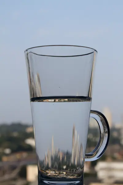 Spiegelung der Stadt in Glas mit klarem Wasser Nahaufnahme — Stockfoto