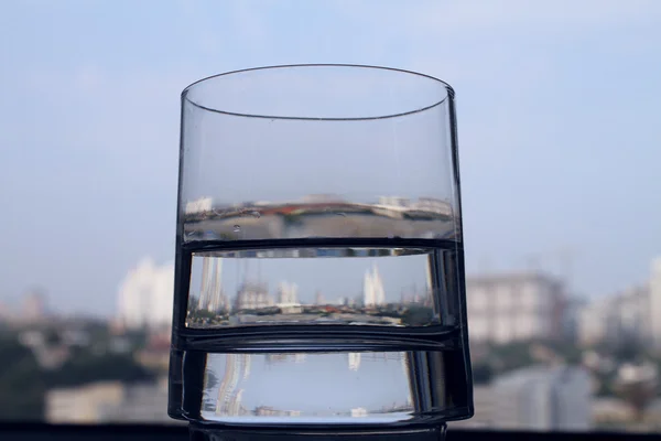 Reflexão da cidade em vidro de closeup de água clara — Fotografia de Stock