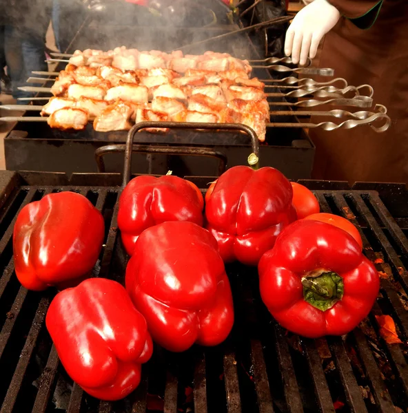 Chef masculin avec des gants blancs faire frire la viande et le paprika rouge sur le gril — Photo