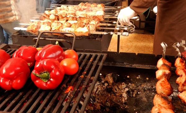 Chef masculin avec des gants blancs faire frire la viande et le paprika rouge sur le gril — Photo