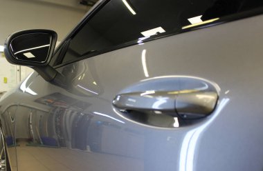The side of the car after being coated with a paint protective coating with a glossy effect