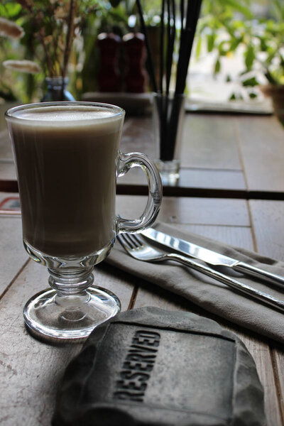 Классическая подача столика в ресторане с чашкой латте в качестве бесплатного напитка