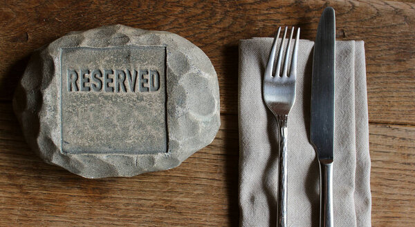Зарезервированное место в ресторане для одного человека с табличкой бронирования на столе