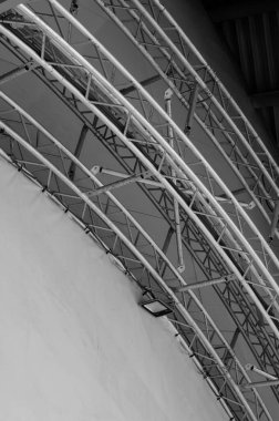 Endüstriyel bir binanın duvarının yanında ateşle mücadele ışığı olan kemerli metal bir kiriş.