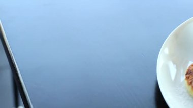 Beyaz bir tabağa serpiştirilmiş toz şeker ve reçel serpiştirilmiş süzme peynirli pankeklerin ayrıntılı panoramik videosu