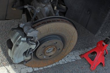 Arızalı fren balataları ve kalibreli montaj silinmiş bir araba tekerleğinin ortasına. 