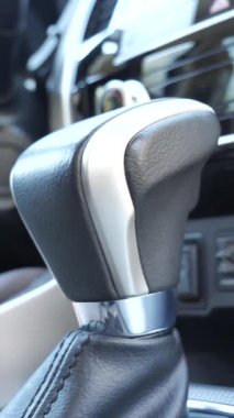 Merkezi tünel ve otomatik vites kolu. Deri kirişli dikey video görüntüsü var.