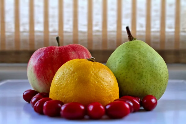 Zitrone, Apfel, Birne und Hartriegel auf weißem Tablett in der Küche — Stockfoto